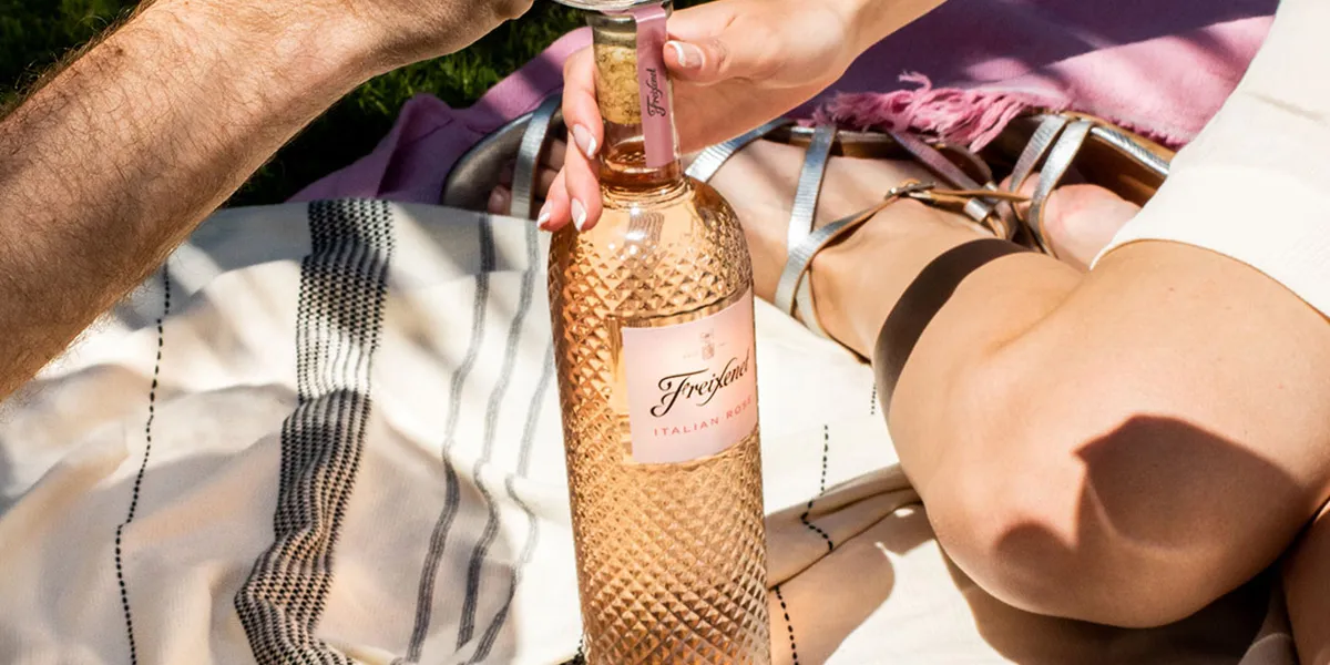 Freixenet Rosé sparkling wine being opened at a picnic, featured in Bargain Booze’s Flavour Fest Drinks Deals.