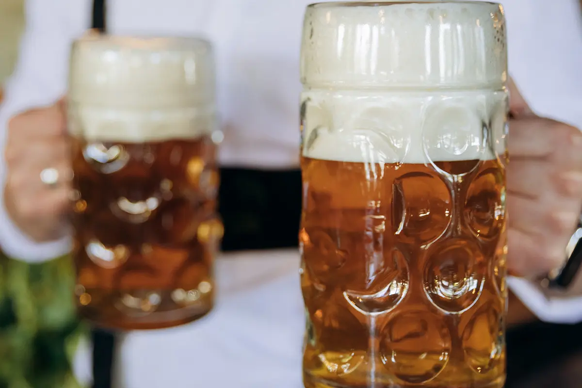 Two frothy steins of lager being served, celebrating Oktoberfest and Freshers Week drinks deals.