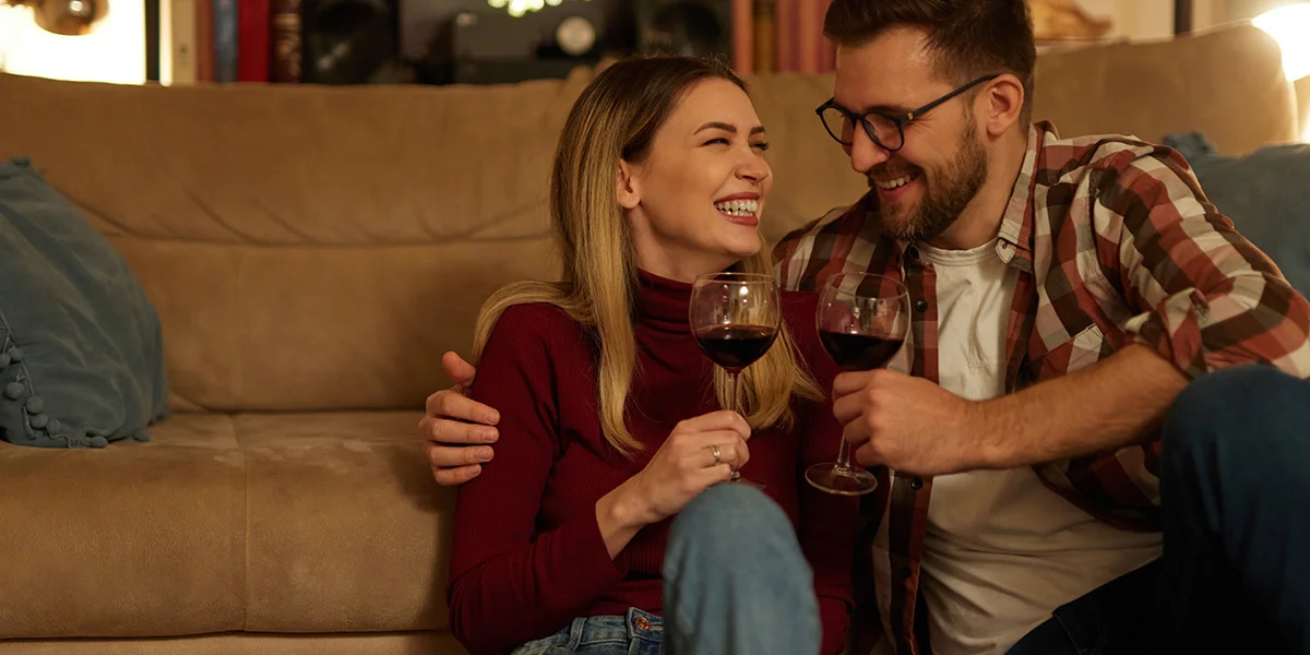 Couple enjoying a cosy night in with wine as part of relaxed Dry January drinks deals and budget friendly evenings at home