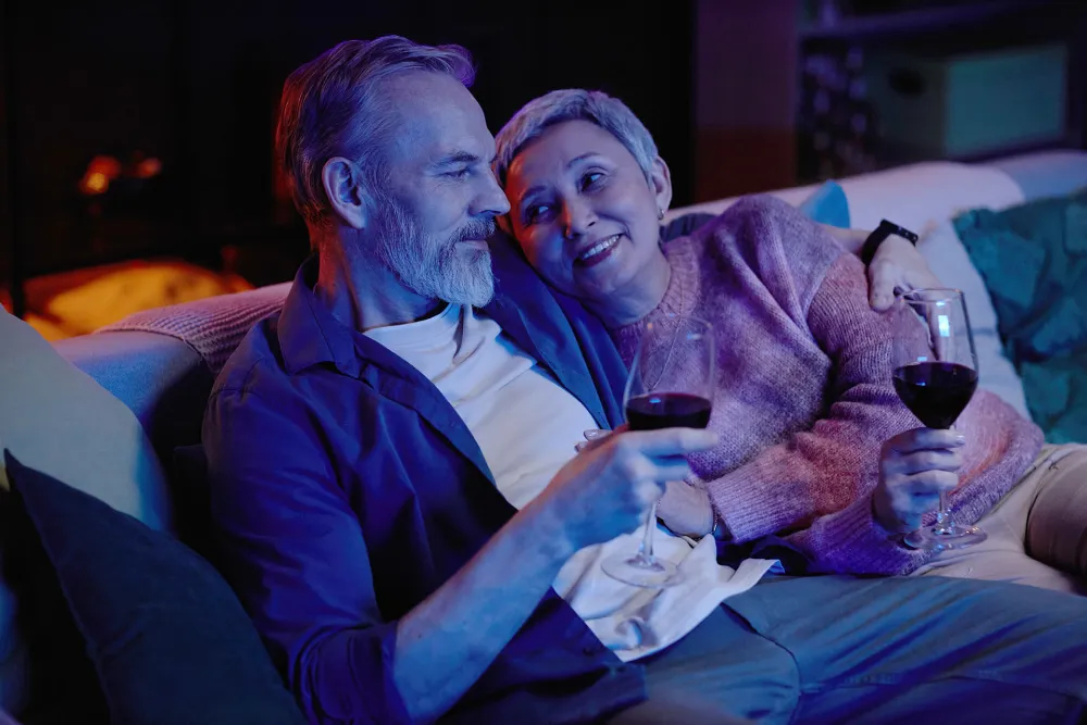 Couple relaxing at home with glasses of red wine