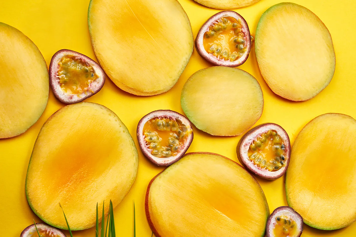 Fresh mango slices and passion fruit on a yellow background