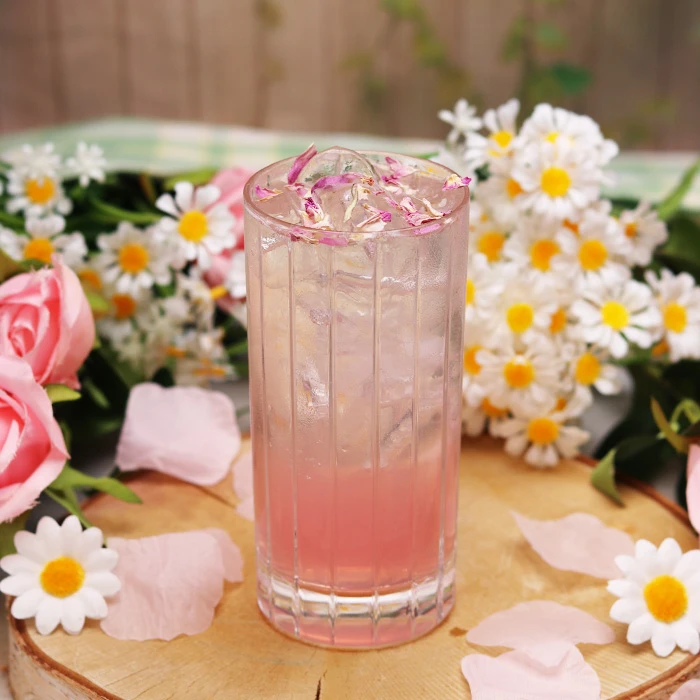 Blossom Rose cocktail with pink floral garnish and fresh daisies, featured in Mum Deserves More & The Irish Deserve a Toast: Mother’s Day and St Patrick’s Day Sorted at Bargain Booze.